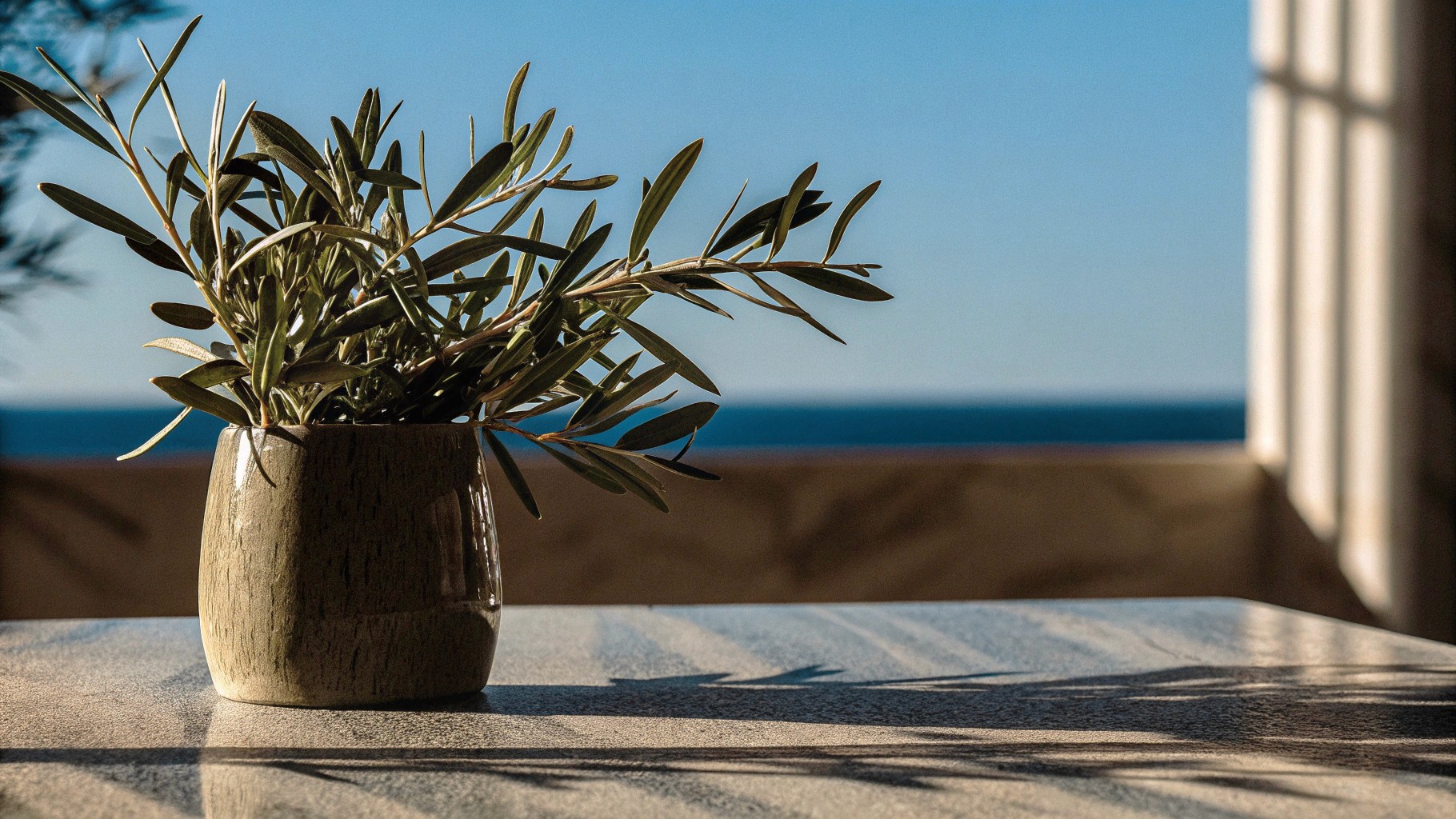 close-up-of-ceramic-vase-with-olive-branches-on-a-clay-pot